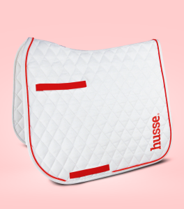 Tapis de selle blanc avec bordures rouges.